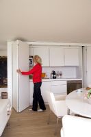 Woman opening concealed kitchen