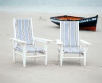 Two chairs and a boat on a beach