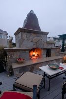 Outdoor kitchen and fireplace with fire