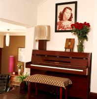 A piano and a portrait on the wall