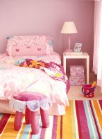 Girls bedroom with bed and lamp on side table