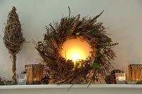 Christmas wreath and candles on mantelpiece 
