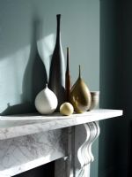 Collection of vases on marble mantelpiece 