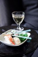 Sushi in a bowl with chopsticks and wine