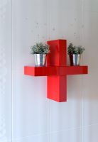 Red cross shaped wall shelf in bathroom