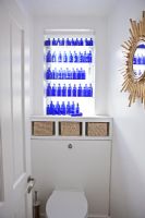 Display of blue bottles in bathroom window