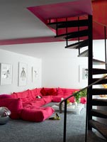 Spiral stairs down to colourful living room
