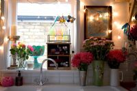 Flowers and fairy lights around kitchen sink 