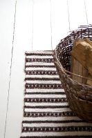 Log basket on striped rug