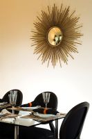 Gold sunburst mirror on dining room wall