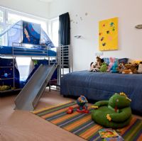 Modern childrens room with slide from the bed