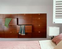 Wooden chest of drawers built into bedroom wall