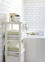 Towels on shelf in modern white bathroom 