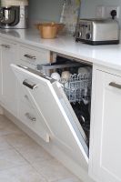 Detail of open modern dishwasher 