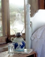 Decorative oil lamp on country bedside table 