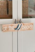 At the beach sign hanging on door handles 