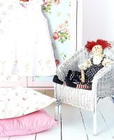 Rag doll on vintage chair in childrens room 