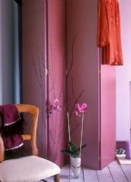 Pink decorative screen with chair and orchid