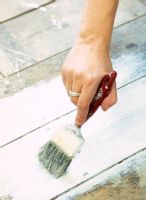 Detail of person painting floorboards 