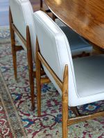 Detail of dining chairs on patterned rug 
