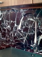 Detail of kitchen sink with marble splashback