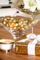 Gold baubles in glass on Christmas table 
