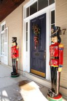 Colourful carved soldiers flanking front door 