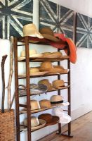Collection of hats on hallway shelf unit 
