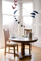 Modern mobile above small round dining table 