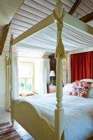 Four poster bed in country bedroom 