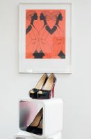 Shoes on display shelving beneath Hermes illustration