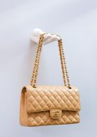 Chanel handbag displayed on wall mounted sculpted hand