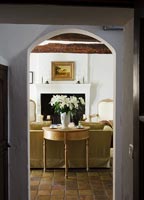 View of country living room through arched door