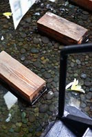 Industrial style water feature and wooden stepping stones