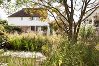 Cottage garden with pond and clapboard house