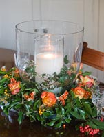 Christmas centre piece of Roses, berries and seasonal foliage