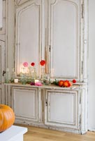 Display of autumnal flowers on vintage french dresser