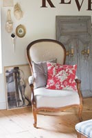 Reupholstered classic armchair with vintage floral cushion