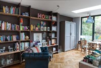 Open plan living space with bookshelves as feature wall