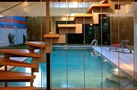 Modern wooden staircase and swimming pool at night