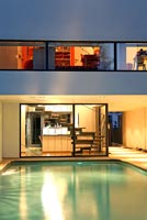 Modern house and pool lit up at night