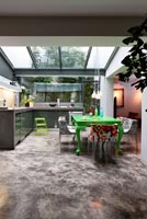 Colourful kitchen diner with concrete floor