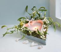 Christmas decoration of Mistletoe and heart shaped candle