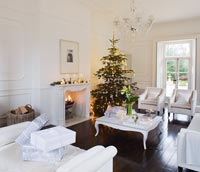 White living room with Christmas tree and presents
