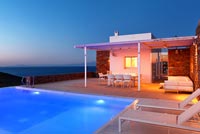 Greek villa and pool lit up at night
