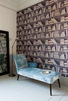 Chaise lounge and patterned wallpaper