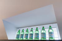Mineral water bottles at kitchen window