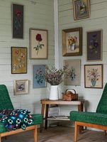 Display of floral paintings on living room wall
