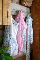 Floral aprons hanging from hooks