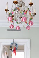 Christmas baubles hanging from chandelier 